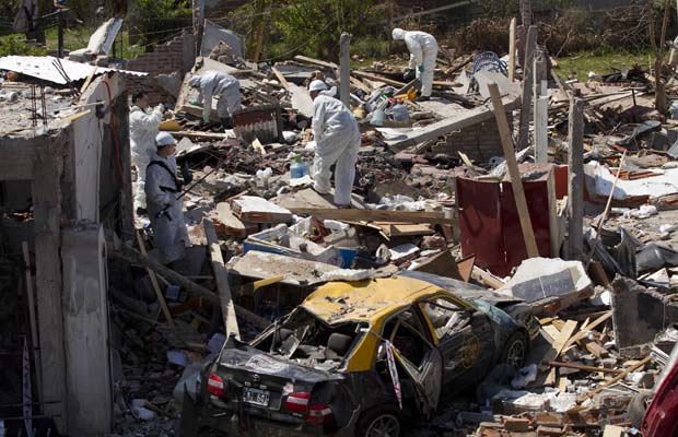 Equipes trabalham no local da explosão nesta segunda-feira (26) próximo a Buenos Aires (Foto: AP)