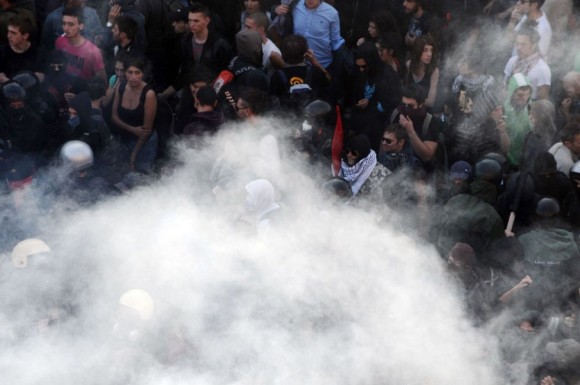 Manifestantes ea polícia italiana em uma nuvem de fumaça no centro de Roma.  Foto: AFP